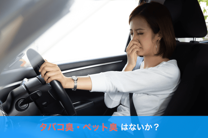 車内で鼻をつまむ女性
